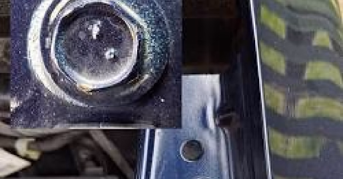 Under-hood view of a fender bolt with intact factory paint covering the hex head, alongside a comparison bolt with disturbed paint indicating removal.