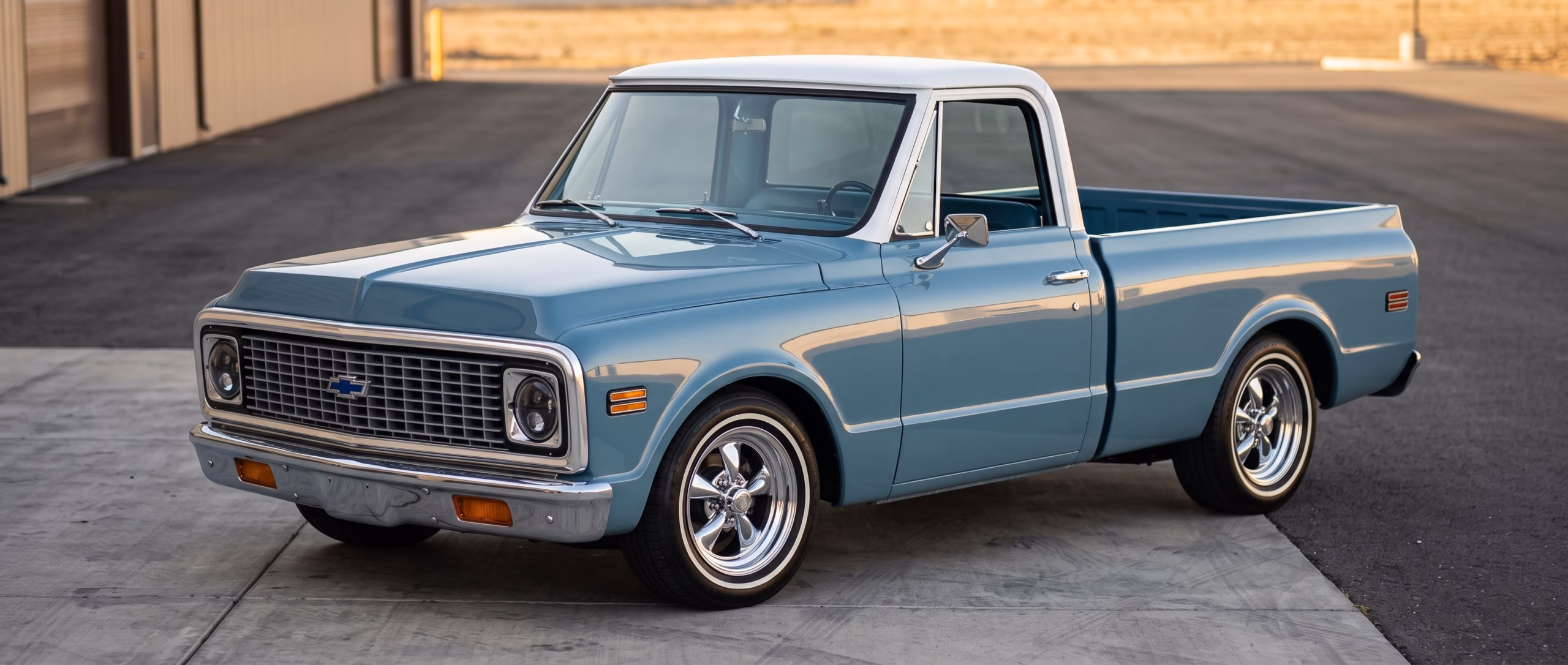A fully restored 1972 Chevrolet C-10 pickup truck in glossy light-blue paint, photographed at a three-quarter front angle showing the completed short-bed conversion, polished chrome grille and bumper, and the tight visual proportions that define the classic-truck aesthetic.