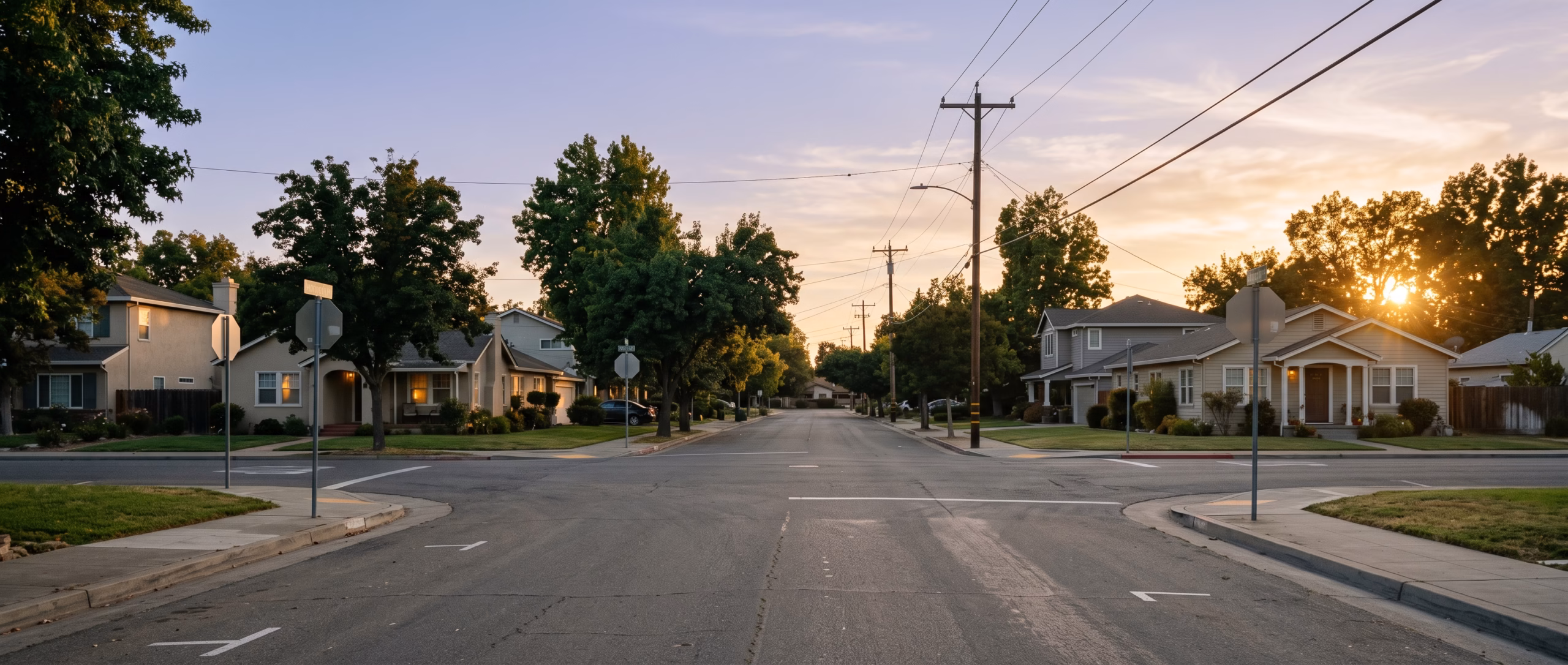 A wide view of a Sacramento-area street at early evening light with soft focus, calm and non-alarming — the kind of ordinary road where a fender-bender might happen, photographed to reassure rather than dramatize.