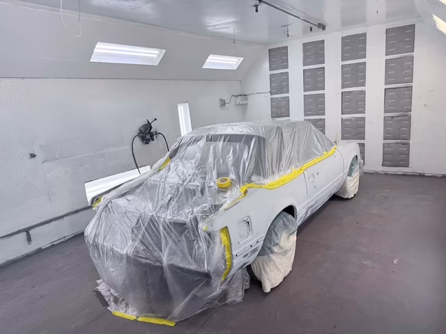 1987 Fox-body Mustang convertible fully masked in the paint booth at Rippers Body Shop