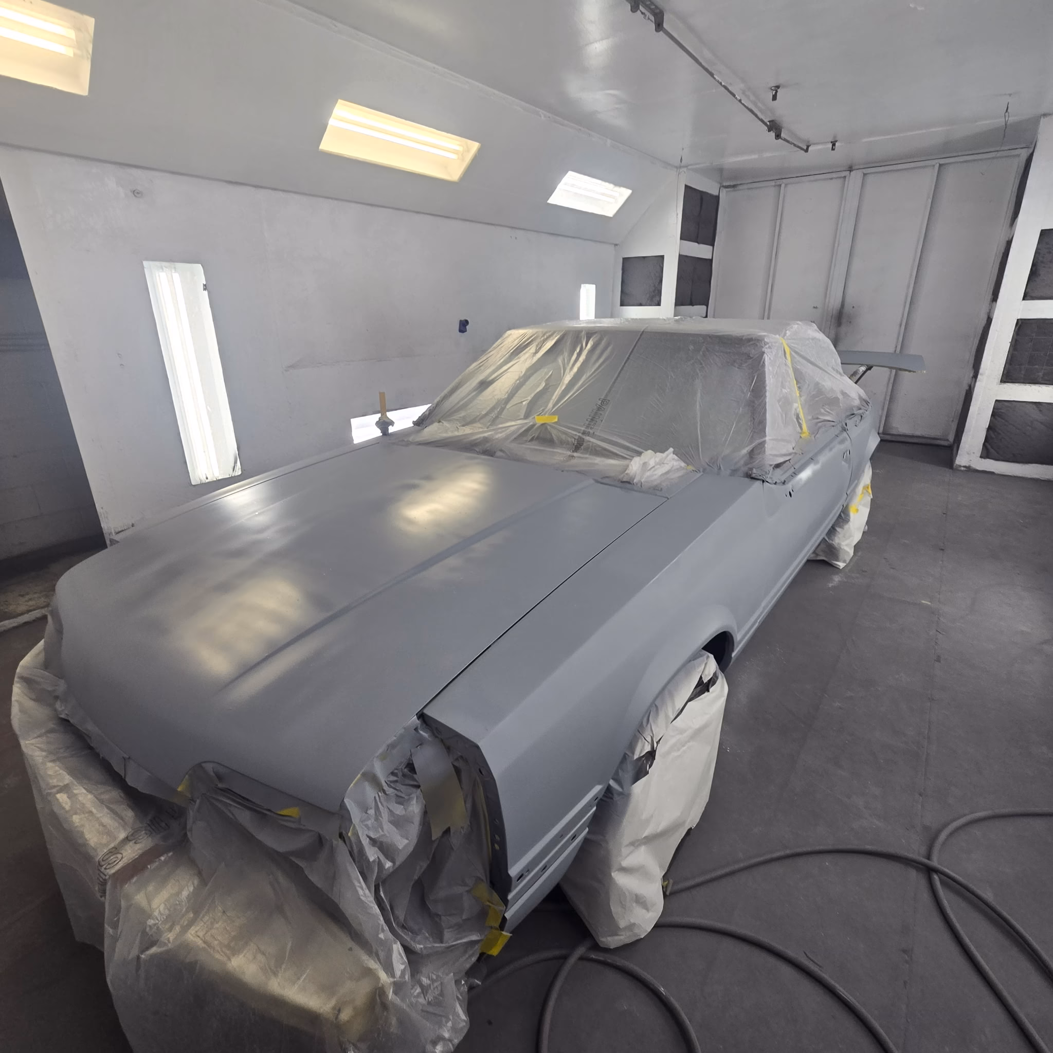 1987 Fox-body Mustang convertible body in primer with straight panels at Rippers Body Shop
